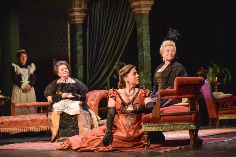 4 women sit in a grand drawing room