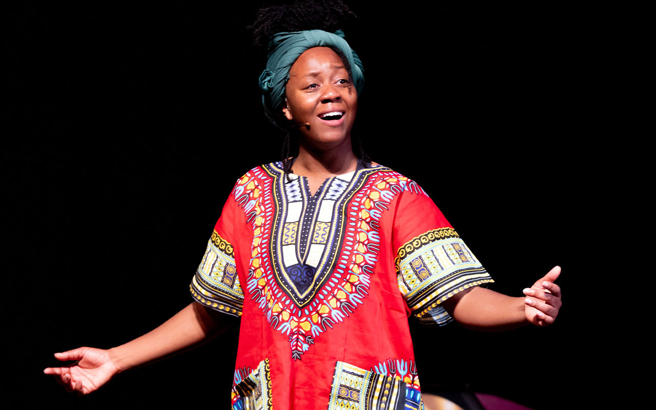 A woman sings with arms outstretched