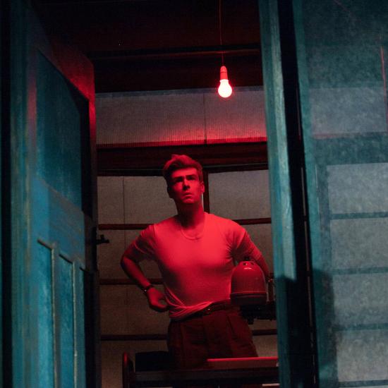 A man stands in a red light