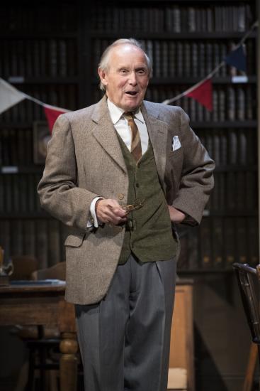 A man stood smiling stood in front of bunting