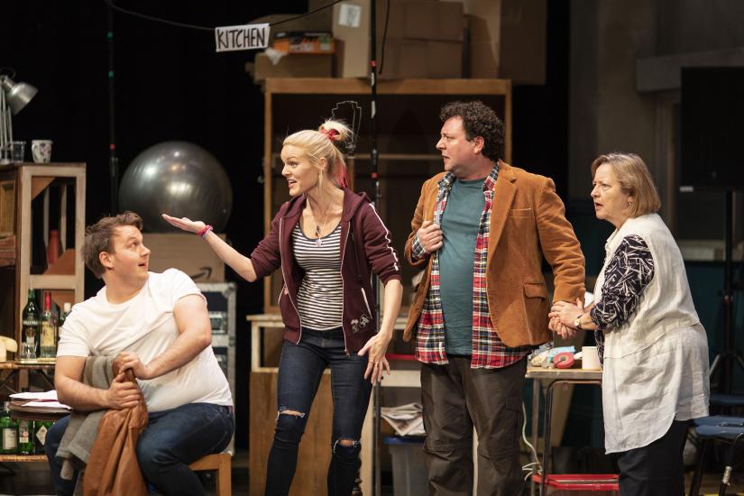 Two men and a woman discuss on stage