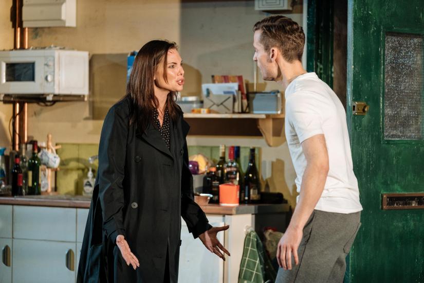 A man and woman argue in a kitchen