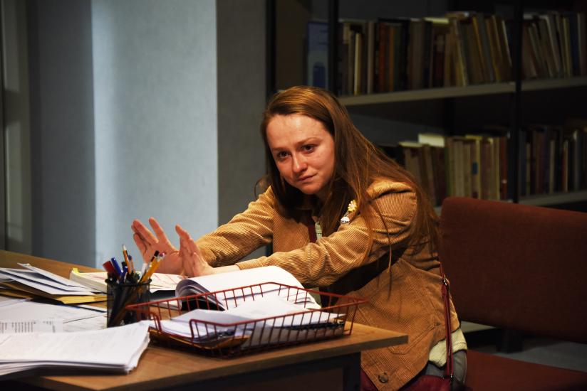 A woman sits at a desk