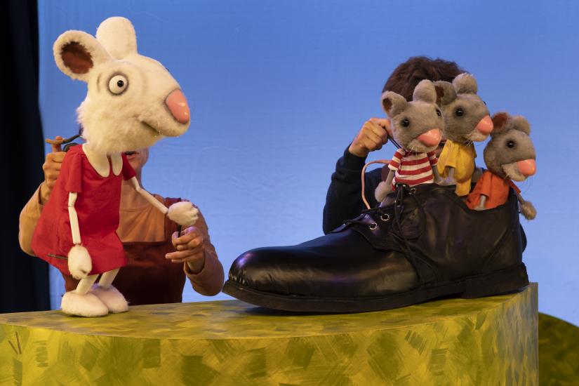 A rabbit talks to three mice, who are sat in a shoe