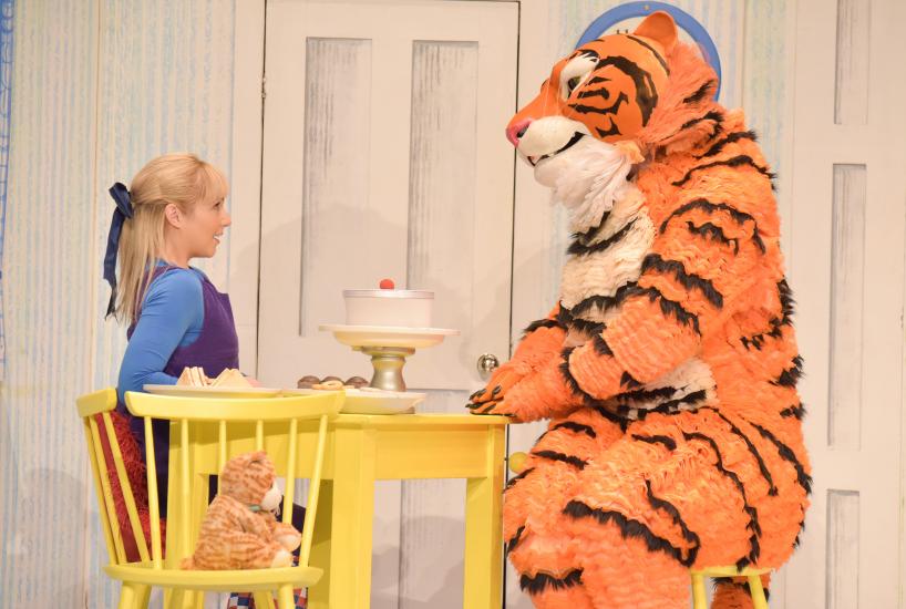 Sophie and the Tiger sit at the kitchen table, there is a large cake on the table