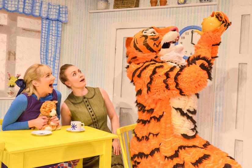 Sophie and her mum sit at the kitchen table next to the Tiger, who is drinking from a teapot