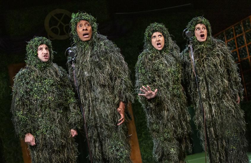 Four people dressed up as leafy bushes