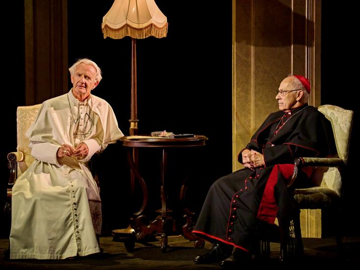 The two popes sit in discussion on armchairs