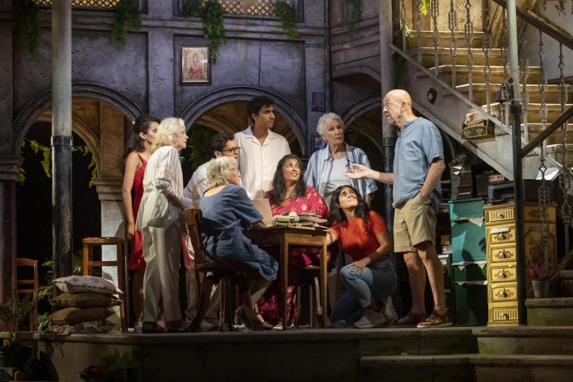 A group of people sit and stand around a table talking