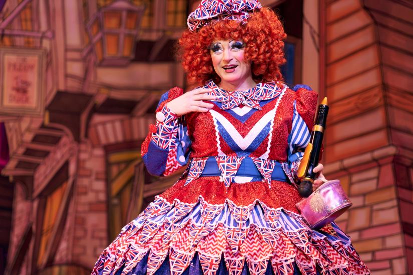 Sarah the Cook wearing a red curly wig and Union Jack dress and hat