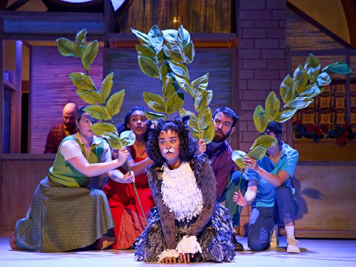 Mog the Cat is outside, cast members hold pieces of greenery up