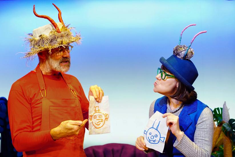 An orange and a blue alien hold up drawings of Smeds and Smoos's faces.