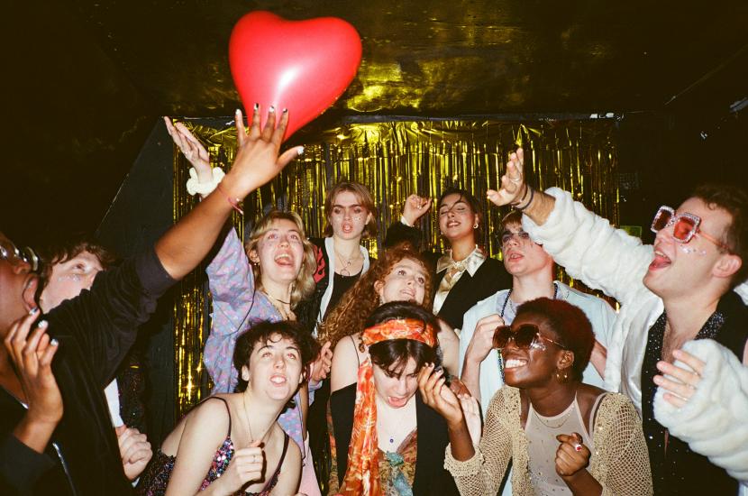 A group of young people in a nightclub singing karaoke 