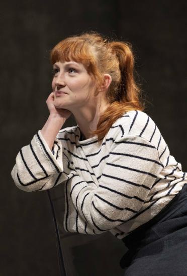 A woman with red hair and a stripy top