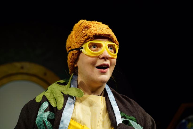 A woman wearing a yellow knitted beanie hat and yellow goggles