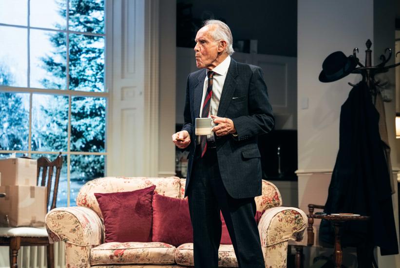 A man stands holding a cup of tea