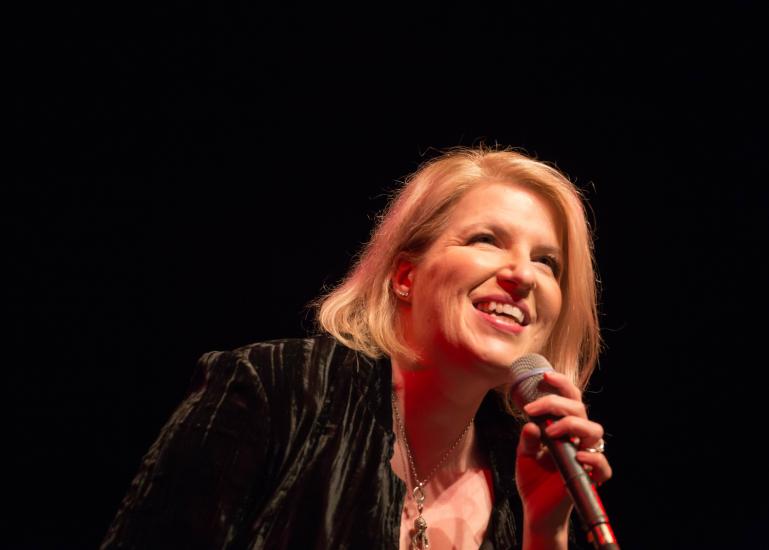 Woman holding mic with black background