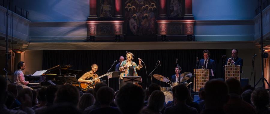 Band performs on stage under icons