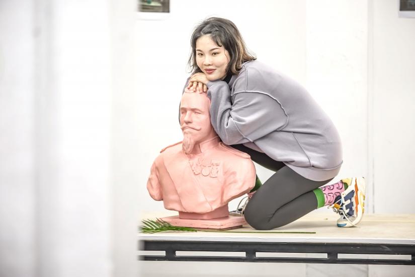 Woman crouches over statue