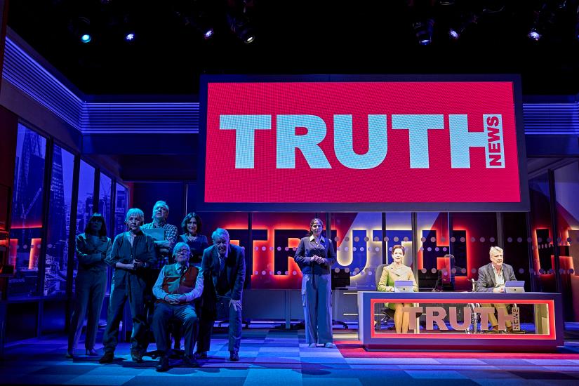 A long distance image of the whol stage, a bit red TRUTH news sign hangs in the back