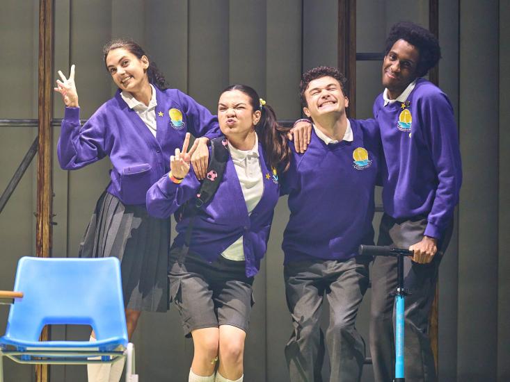 Group of actors portraying children stand posing