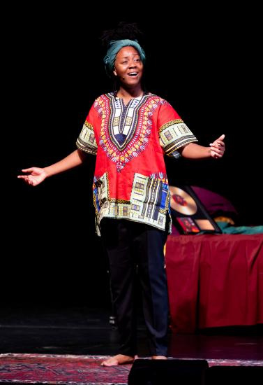 Nicholle Cherrie as Nina Simone on stage, she stands with arms outstretched