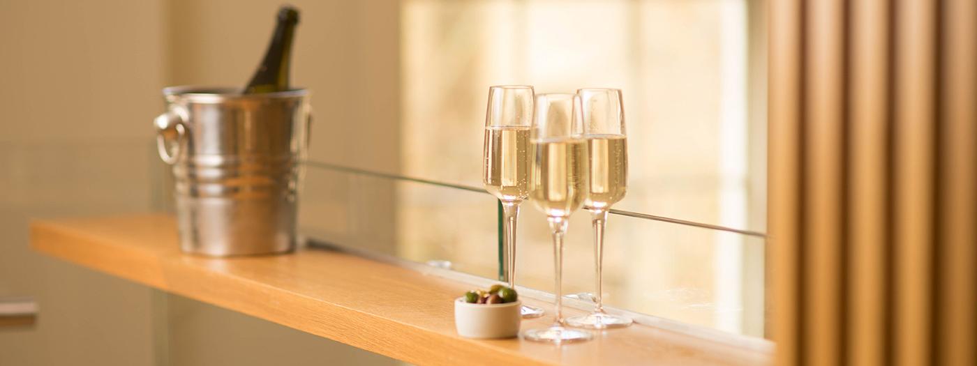 Glasses of fizz on a bar next to the bucket containing the bottle