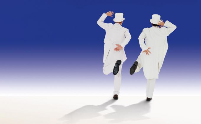 Two men in white suits and white top hats run into the distance