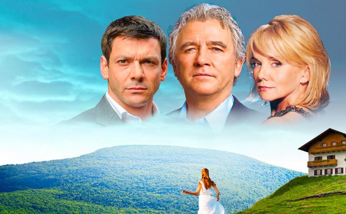 The background is of mountains, a lodge sits on top of a peak. The two male and one female face of the cast are superimposted onto the skyline
