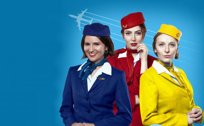 Three air hostesses with different coloured uniforms on