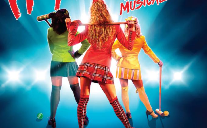 Heathers main image - three women stand with their back to the image wearing a school uniform holding