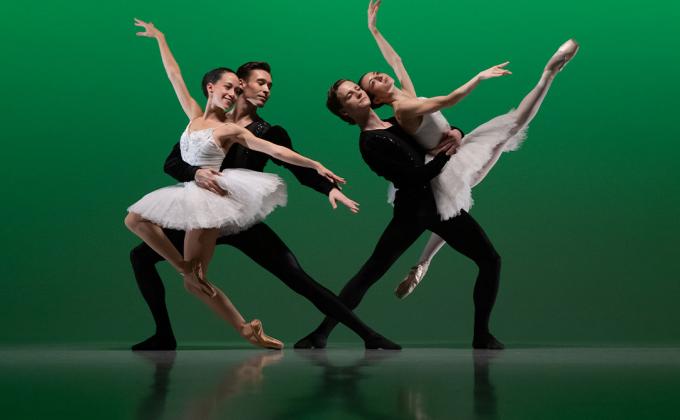 Two pairings of male and female dancers in traditional tutus and black costumes