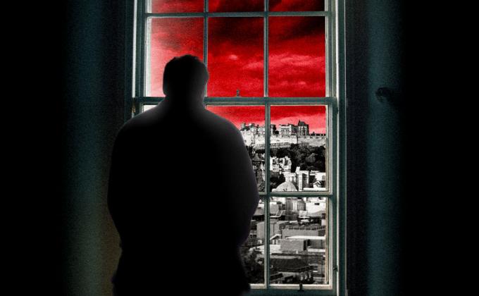 A man in shadows looks out of a window, the sky is red