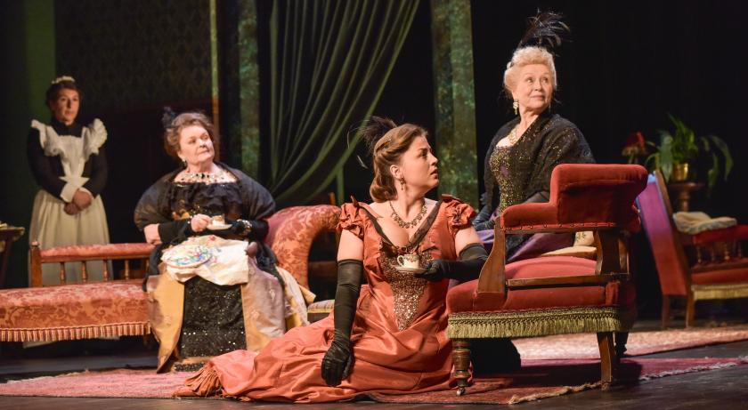 a group of Victorian women sit on the floor