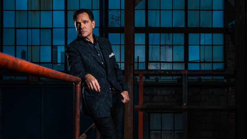 Kurt Elling leans against a red railing