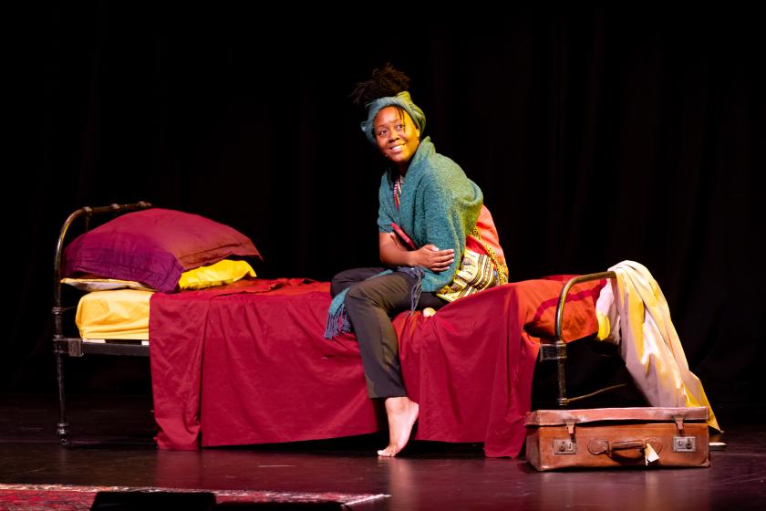 A woman sits on a bed
