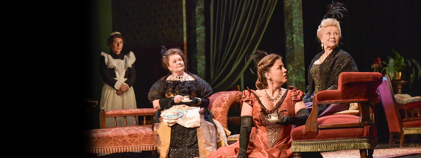 3 upper-class women sit on plush furniture, a maid stands behind them.