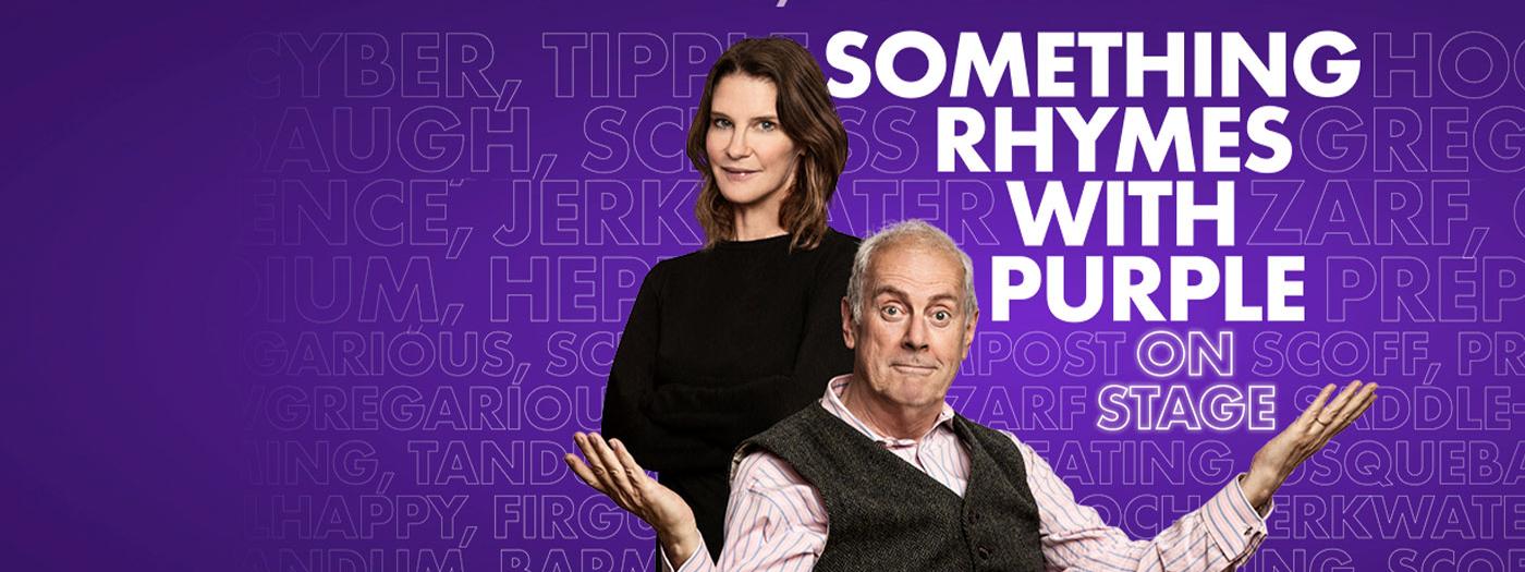 Gyles Brandreth raises his hands in a questioning manner, Susie Dent stands behind