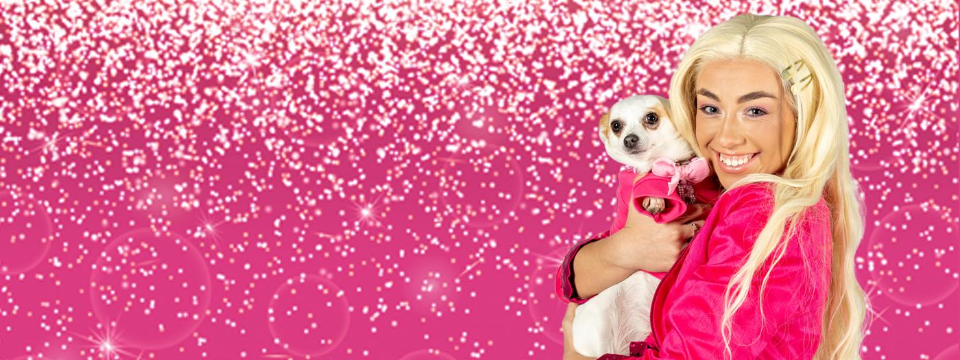 A blonde woman in a pink dress holds a Chihuahua