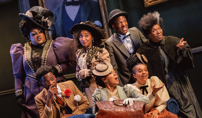 A group of actors in costume look towards the camera