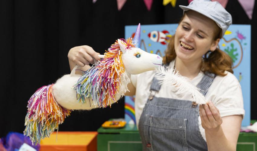 A colourful unicorn puppet with a feather